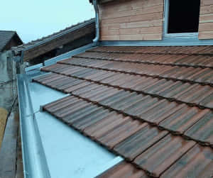 Travaux de zinguerie sur faux rang d'égout de couverture en tuiles