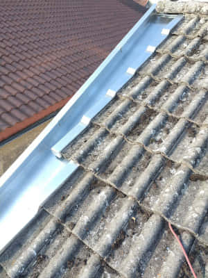 Réalisation d'un couloir en zinc avec noquet et bande de rive sur tuiles béton